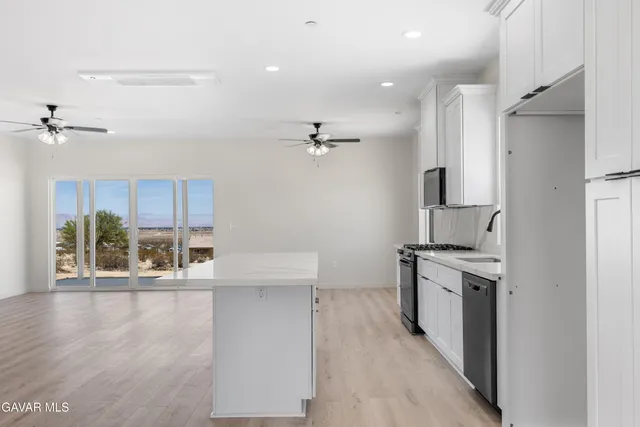 a view of a kitchen with a sink wooden floor and a living room