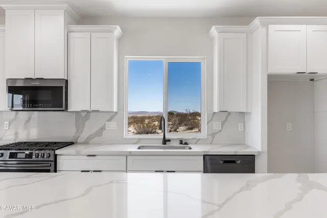 a kitchen with stainless steel appliances granite countertop a sink and a stove