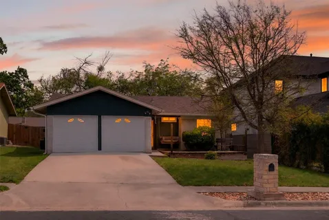 a front view of a house with a yard and trees