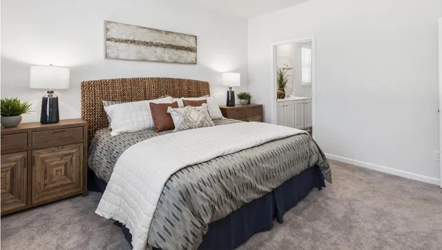 a large bed sitting in a bedroom next to a window