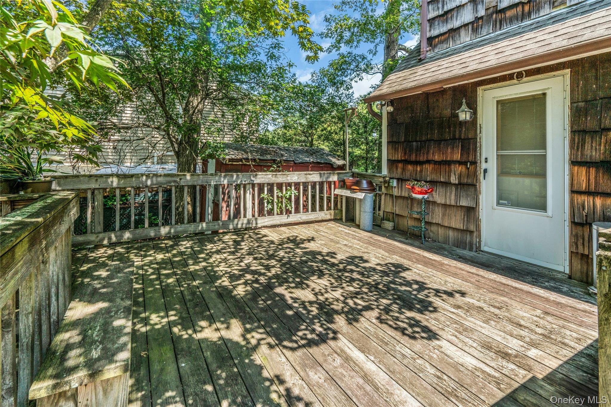 42 Summit Street Plainview, NY 11803 - Photo 22 of 22 a view of a deck with a floor to ceiling window and wooden fence