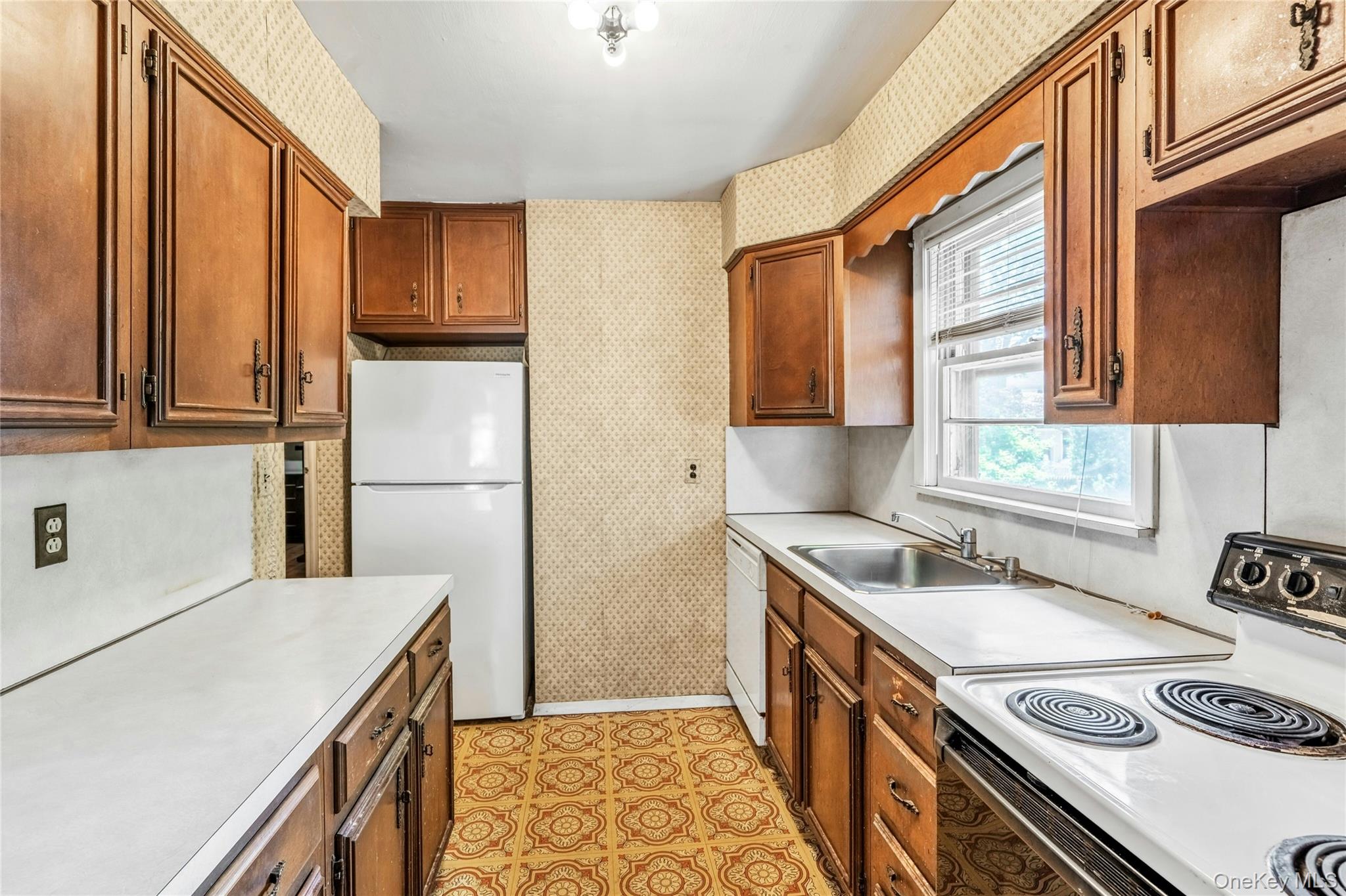 42 Summit Street Plainview, NY 11803 - Photo 10 of 22 a kitchen with a stove a sink and a refrigerator