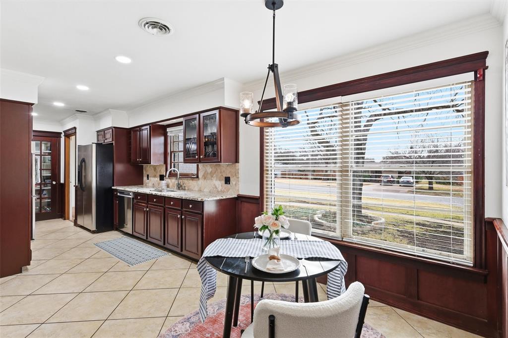 6724 Kirkwood Road Fort Worth, TX 76116 - Photo 22 of 40 a kitchen with stainless steel appliances kitchen island granite countertop a refrigerator a sink dishwasher a dining table and chairs with wooden floor