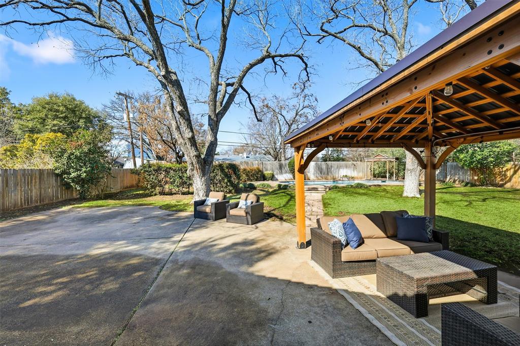 6724 Kirkwood Road Fort Worth, TX 76116 - Photo 32 of 40 a view of a patio with couches and table and chairs under an umbrella