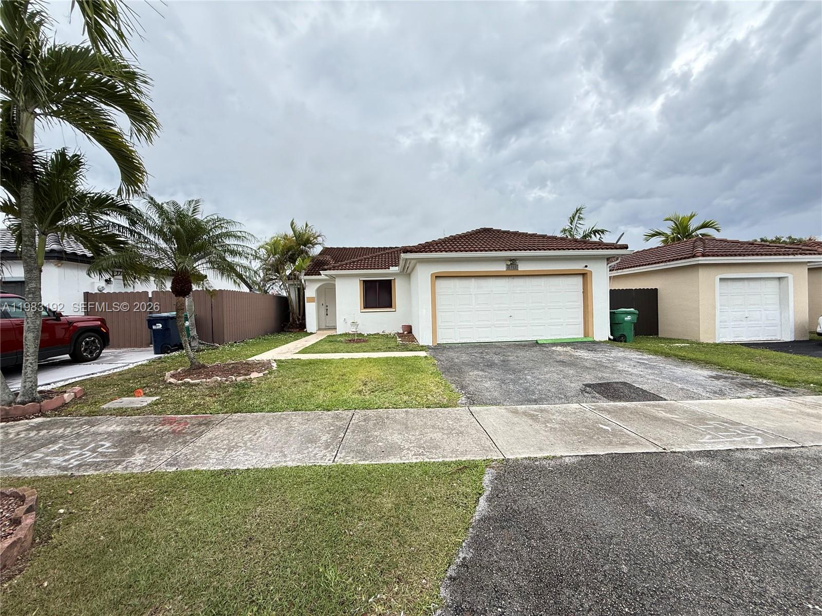 18260 Southwest 142nd Place Miami, FL 33177 - Photo 1 of 30 a front view of a house with a yard and potted plants