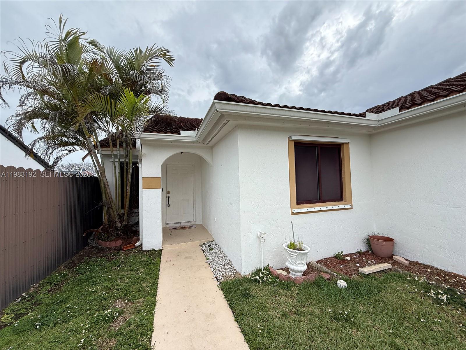 18260 Southwest 142nd Place Miami, FL 33177 - Photo 2 of 30 a front view of a house with a yard