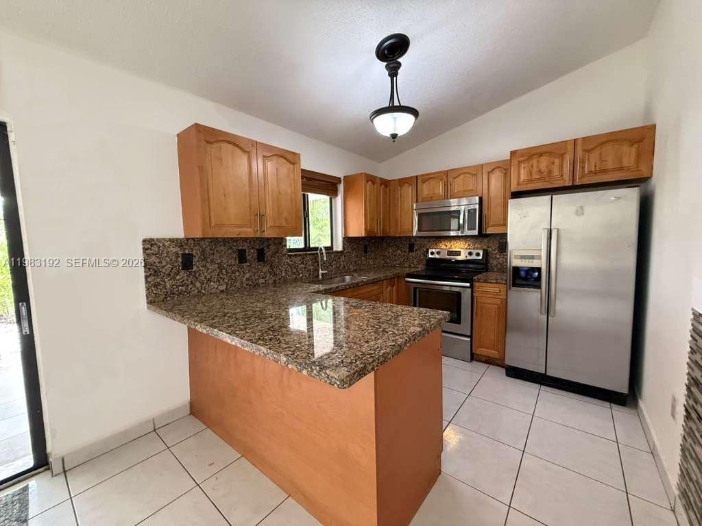 18260 Southwest 142nd Place Miami, FL 33177 - Photo 3 of 30 a kitchen with stainless steel appliances granite countertop a sink refrigerator and microwave