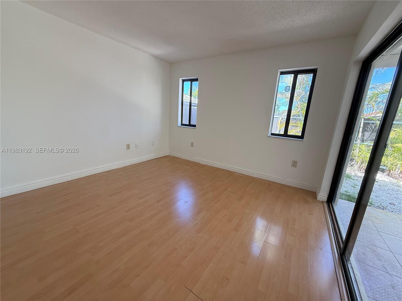 18260 Southwest 142nd Place Miami, FL 33177 - Photo 6 of 30 a view of an empty room with wooden floor and a window
