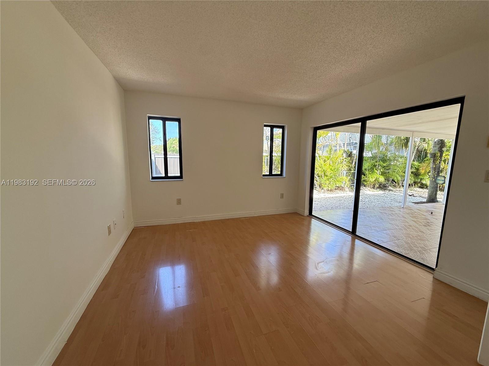 18260 Southwest 142nd Place Miami, FL 33177 - Photo 7 of 30 a view of an empty room with wooden floor and a window