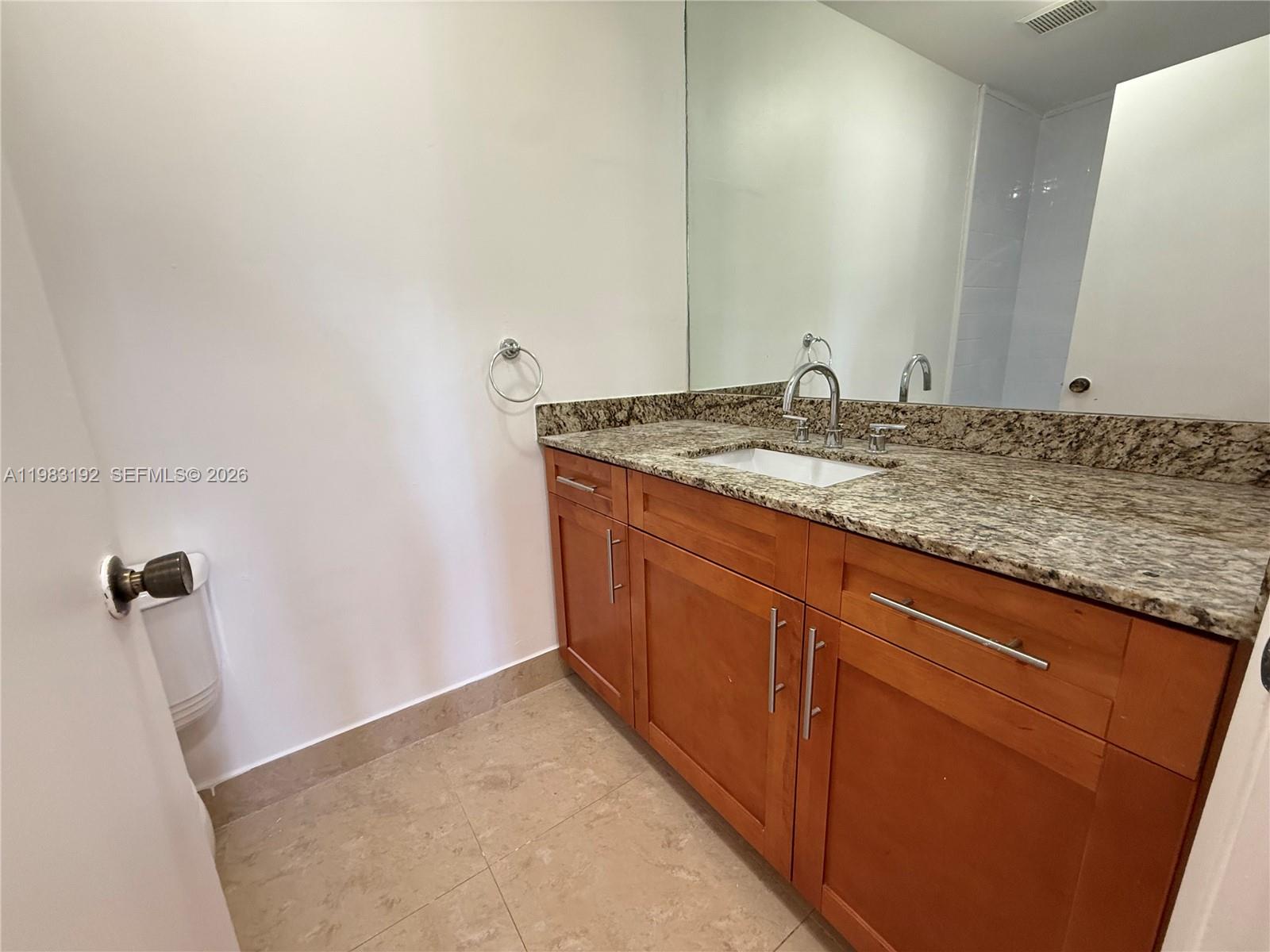 18260 Southwest 142nd Place Miami, FL 33177 - Photo 9 of 30 a bathroom with a granite countertop sink and a mirror
