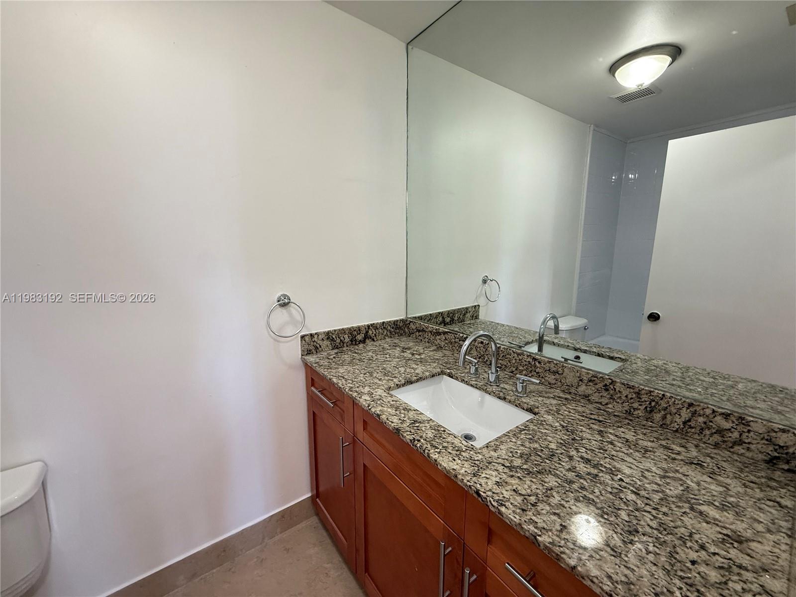 18260 Southwest 142nd Place Miami, FL 33177 - Photo 10 of 30 a bathroom with a granite countertop sink and a mirror