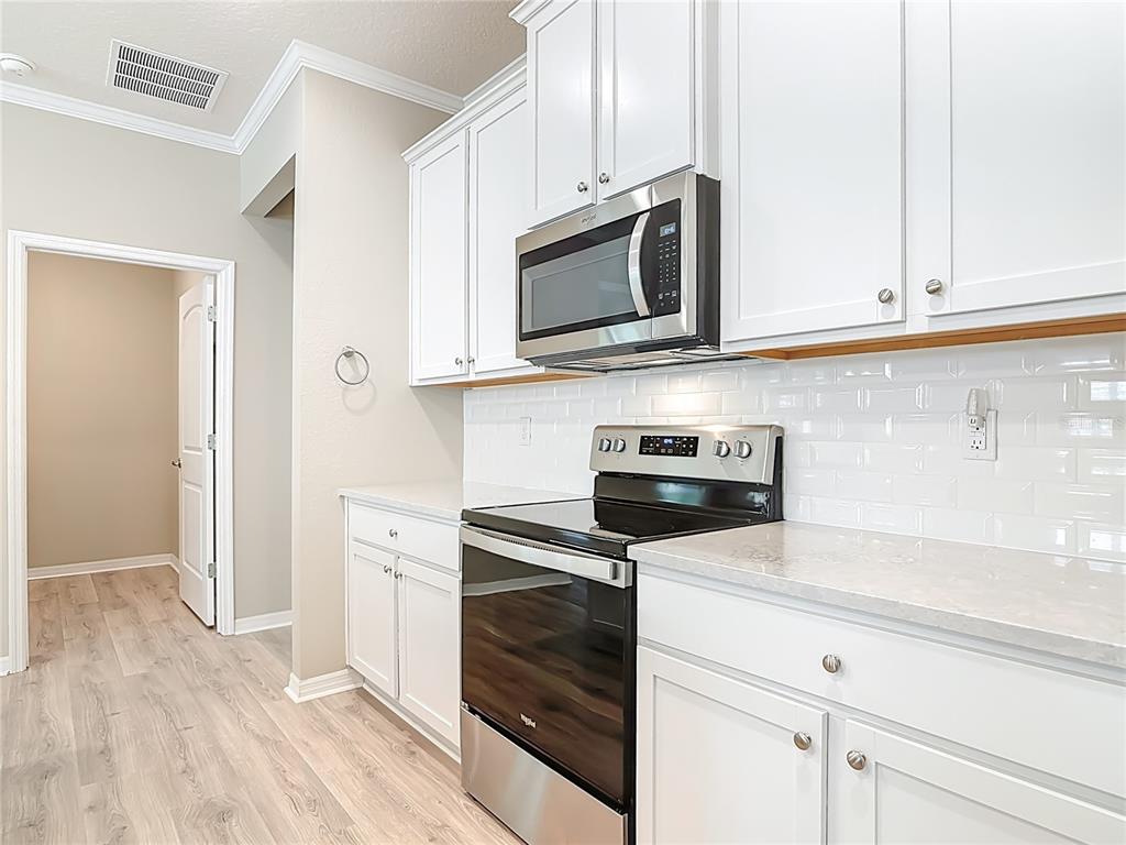 1632 Delphi Way New Smyrna Beach, FL 32168 - Photo 15 of 52 a kitchen with cabinets stainless steel appliances and wooden floor