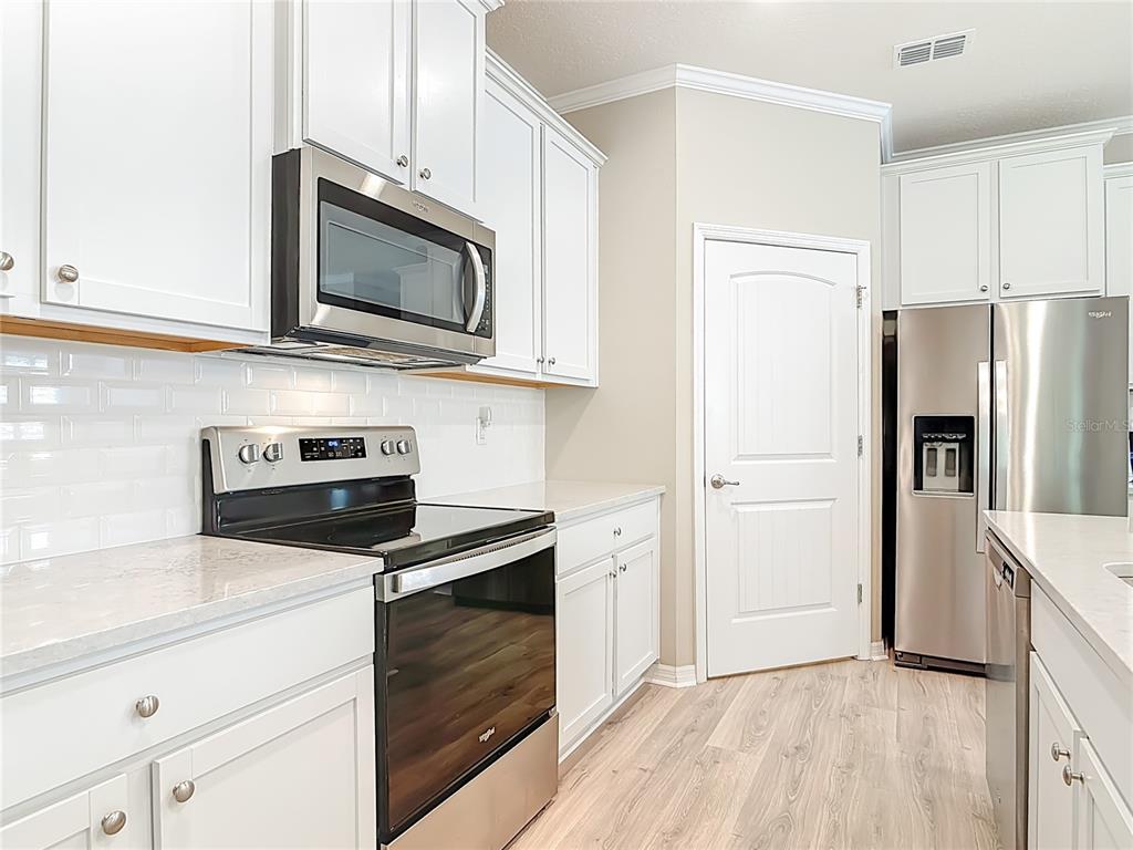 1632 Delphi Way New Smyrna Beach, FL 32168 - Photo 17 of 52 a kitchen with cabinets stainless steel appliances and wooden floor