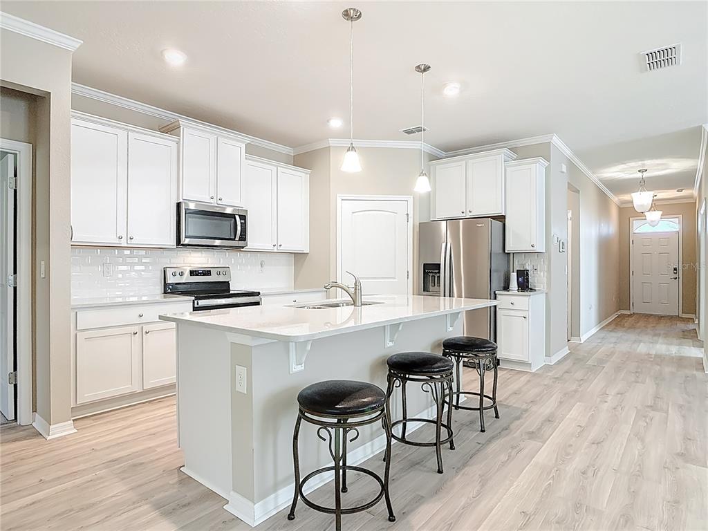 1632 Delphi Way New Smyrna Beach, FL 32168 - Photo 19 of 52 a kitchen with appliances a sink cabinets and wooden floor