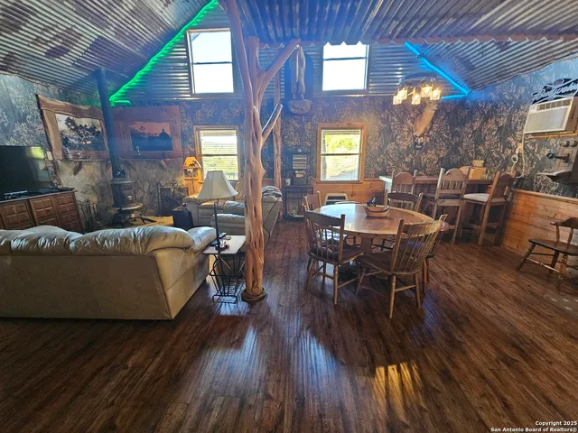 a living room with furniture dining table wooden floor and a large window
