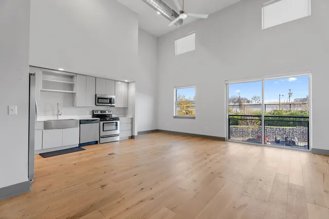 a kitchen with stainless steel appliances kitchen island granite countertop a refrigerator and a sink