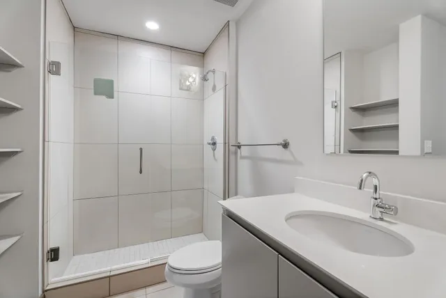 a bedroom with a bed and a lamp on dresser