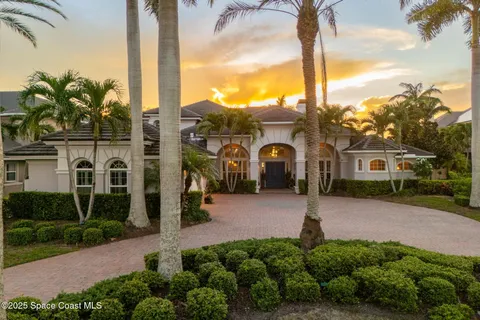 a front view of a house with a yard and potted plants