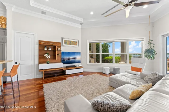 a living room with furniture kitchen view and a wooden floor