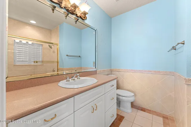 a bathroom with a sink a toilet a mirror and shower