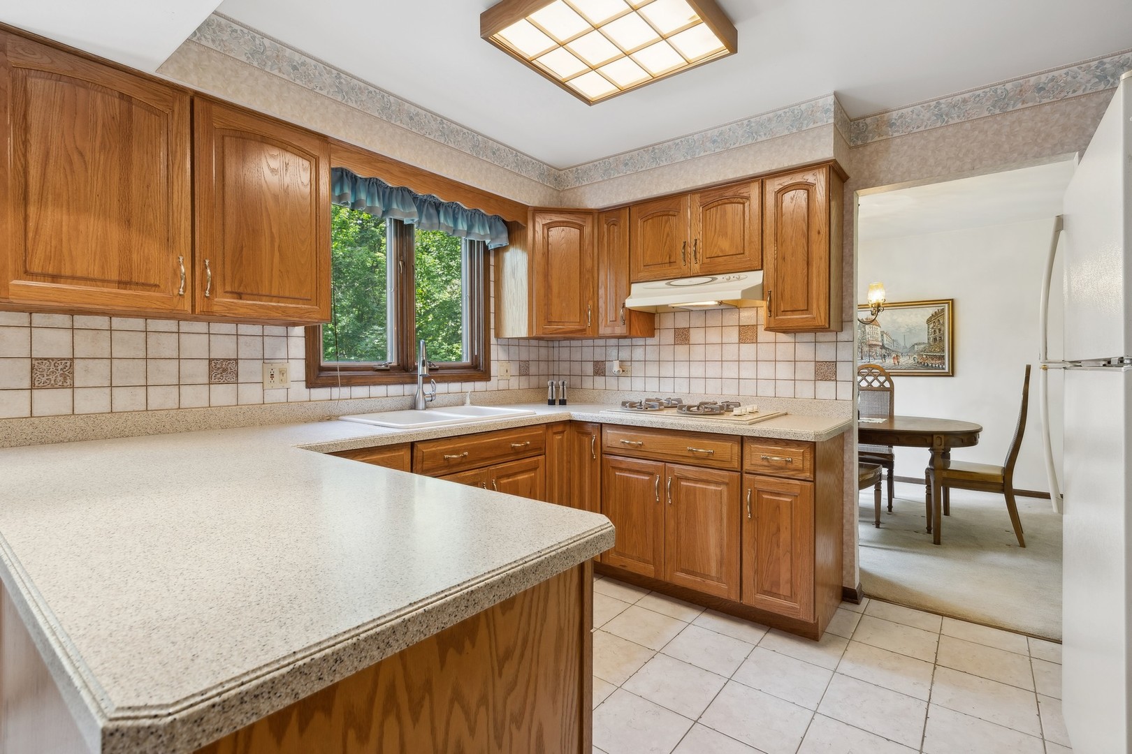 40W173 Oak Ridge Road St. Charles, IL 60175 - Photo 12 of 38 a kitchen with stainless steel appliances granite countertop wooden cabinets a sink and a large window