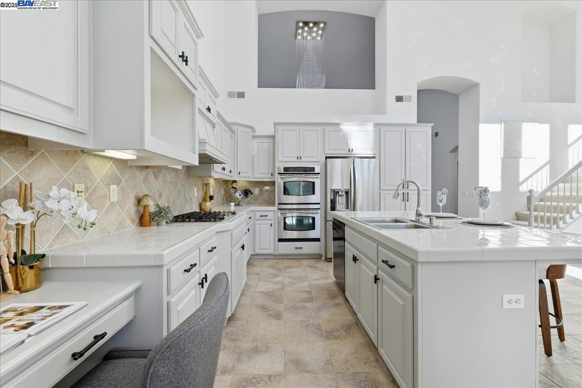 2455 Covelite Way Antioch, CA 94531 - Photo 18 of 60 a large kitchen with stainless steel appliances granite countertop a lot of counter space and wooden floor