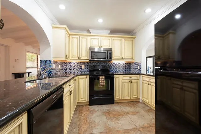 a kitchen with a refrigerator a sink a stove and cabinets