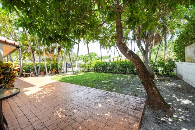 a backyard of a house with potted plants and a bench