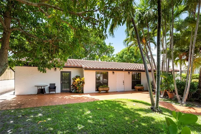 a view of a house with backyard and a tree