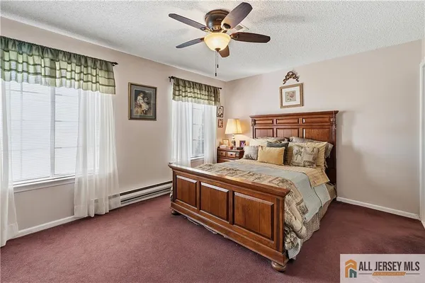a bed sitting in a spacious bedroom next to a window