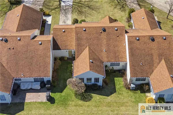 an aerial view of a house with a yard and large tree