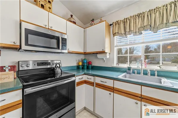 a kitchen with stainless steel appliances a stove sink and microwave