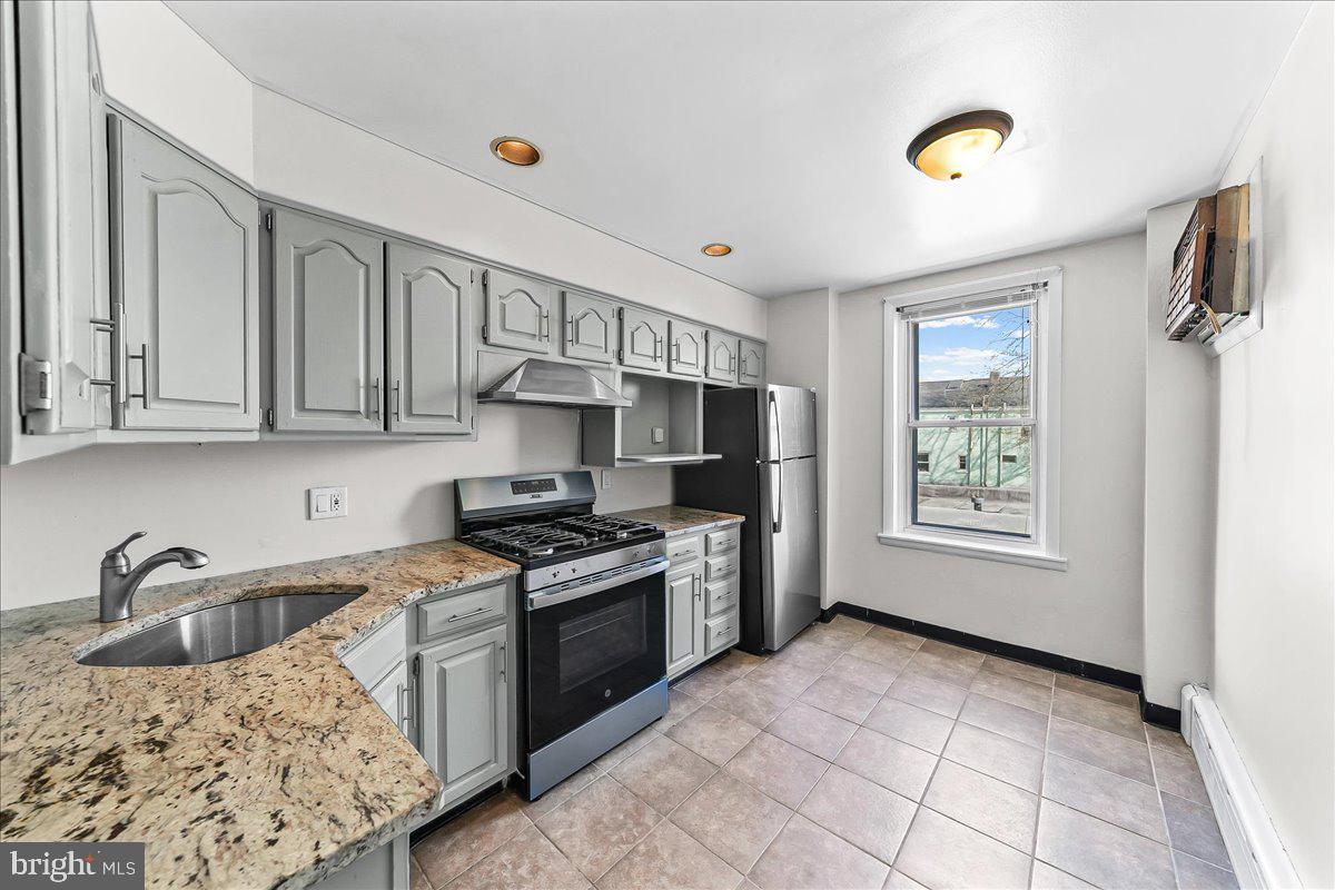 3654 Calumet Street Philadelphia, PA 19129 - Photo 17 of 33 a kitchen with stainless steel appliances granite countertop a sink stove and cabinets