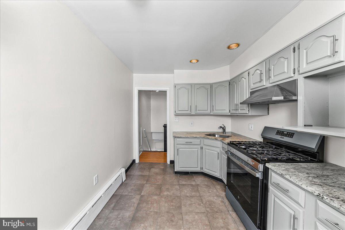 3654 Calumet Street Philadelphia, PA 19129 - Photo 18 of 33 a kitchen with stainless steel appliances granite countertop a stove and a sink