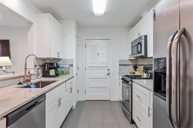 a kitchen with white cabinets and stainless steel appliances