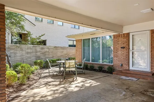 a view of patio with a table and chairs and potted plants