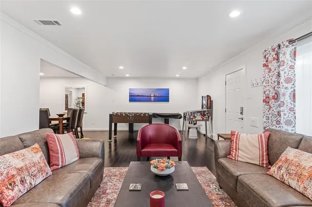 a room with furniture pool table wooden floor and windows