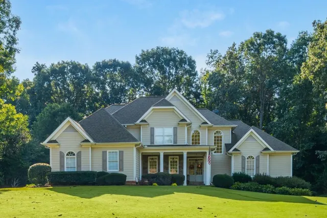 a front view of a house with yard and green space