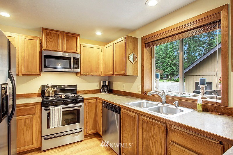 19908 4th Avenue Southeast Bothell, WA 98012 - Photo 5 of 21 a kitchen with stainless steel appliances a stove sink microwave and cabinets