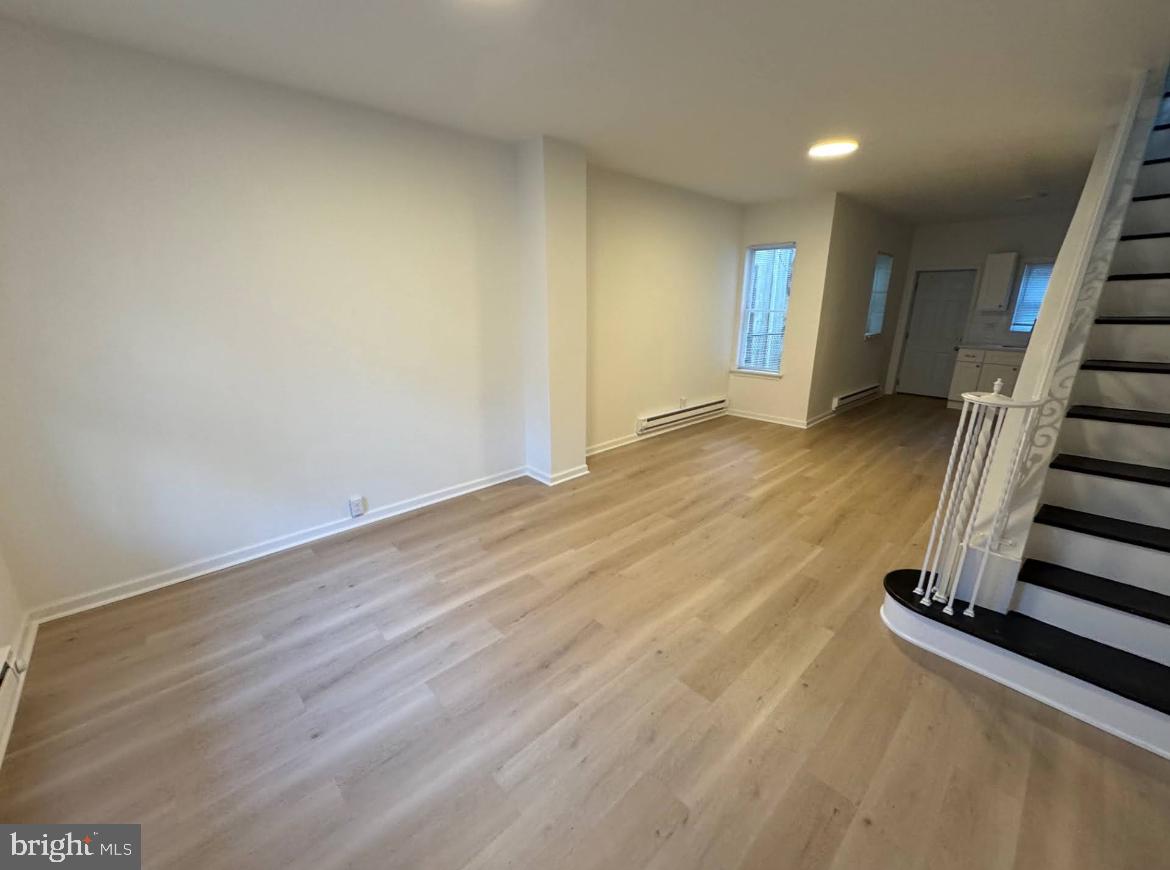3252 Hope Street Philadelphia, PA 19140 - Photo 17 of 19 an empty room with wooden floor and stairs