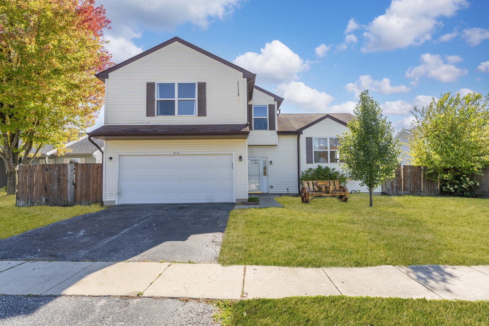a front view of house with yard and trees in the background