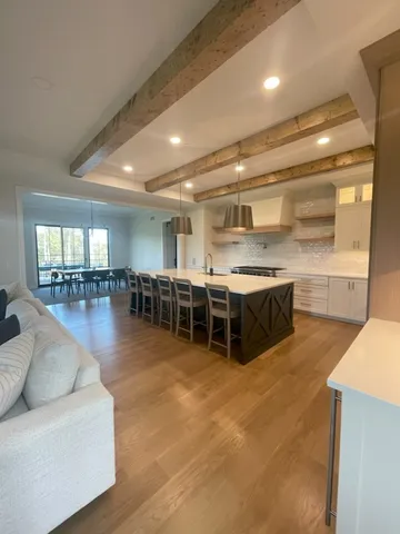 a living room with furniture a table and kitchen view