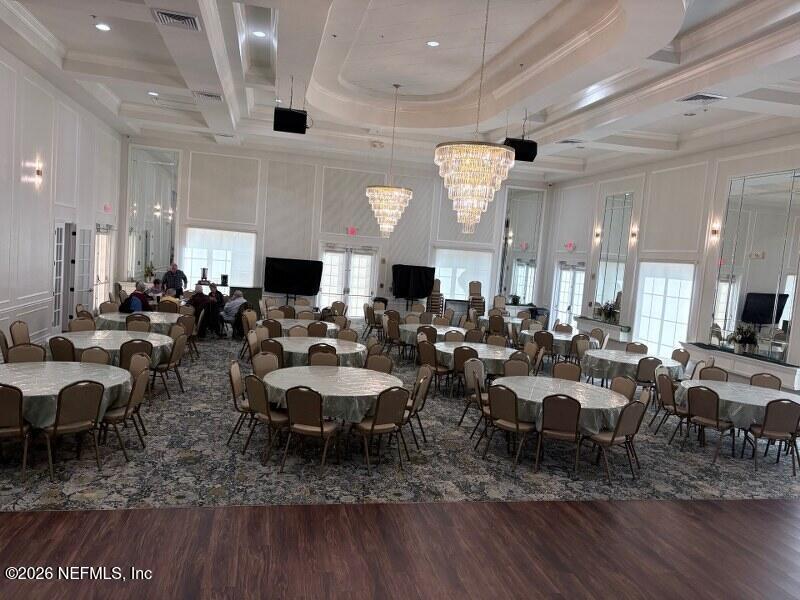 1330 Castle Pines Circle St. Augustine, FL 32092 - Photo 56 of 57 a room with lots of tables a large window and chairs