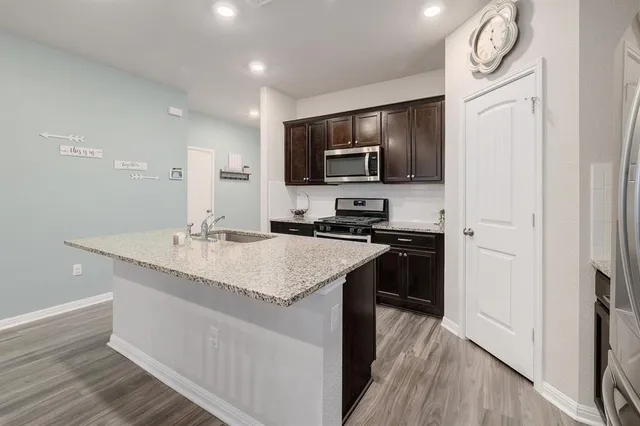a kitchen with stainless steel appliances granite countertop a sink stove and refrigerator