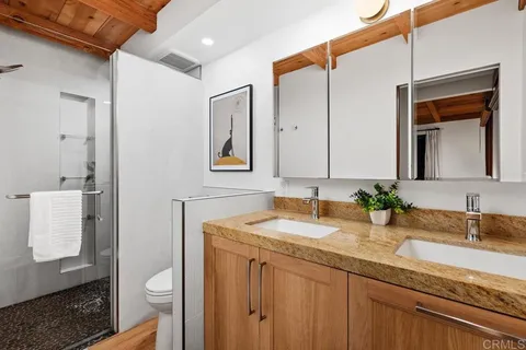 a bathroom with a sink a toilet and shower