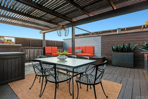 a view of a patio with table and chairs under an umbrella