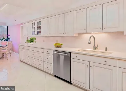 a kitchen with cabinets stainless steel appliances a sink and wooden floor