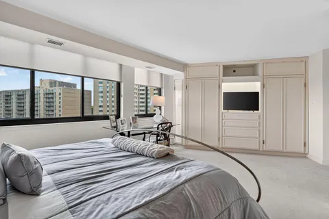 a bedroom with a large bed and a flat tv screen