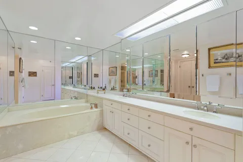 a bathroom with a granite countertop sink mirror and bathtub