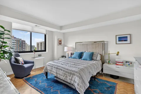 a bedroom with a bed and large windows